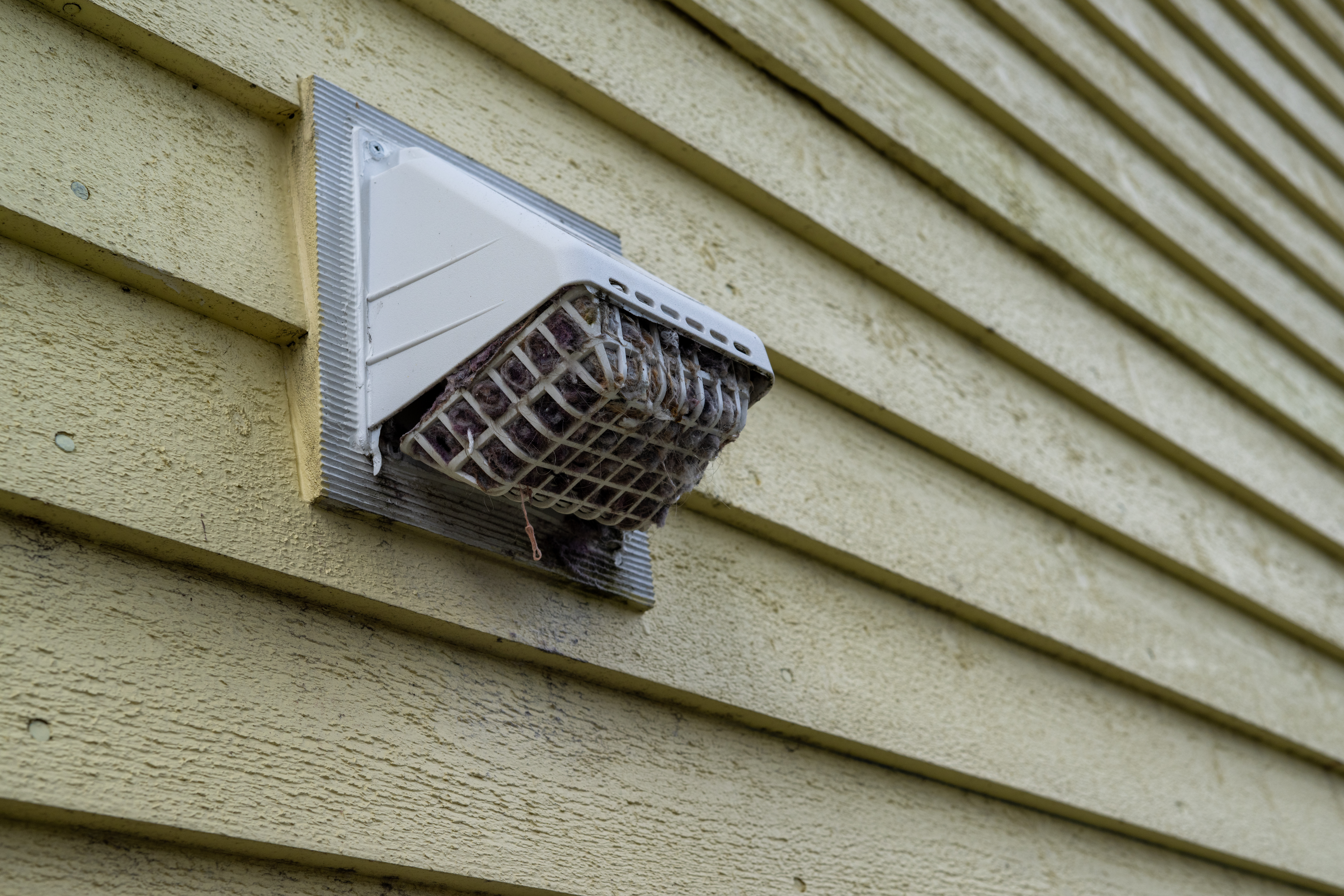A close up of a dryer vent that needs to be cleaned. 