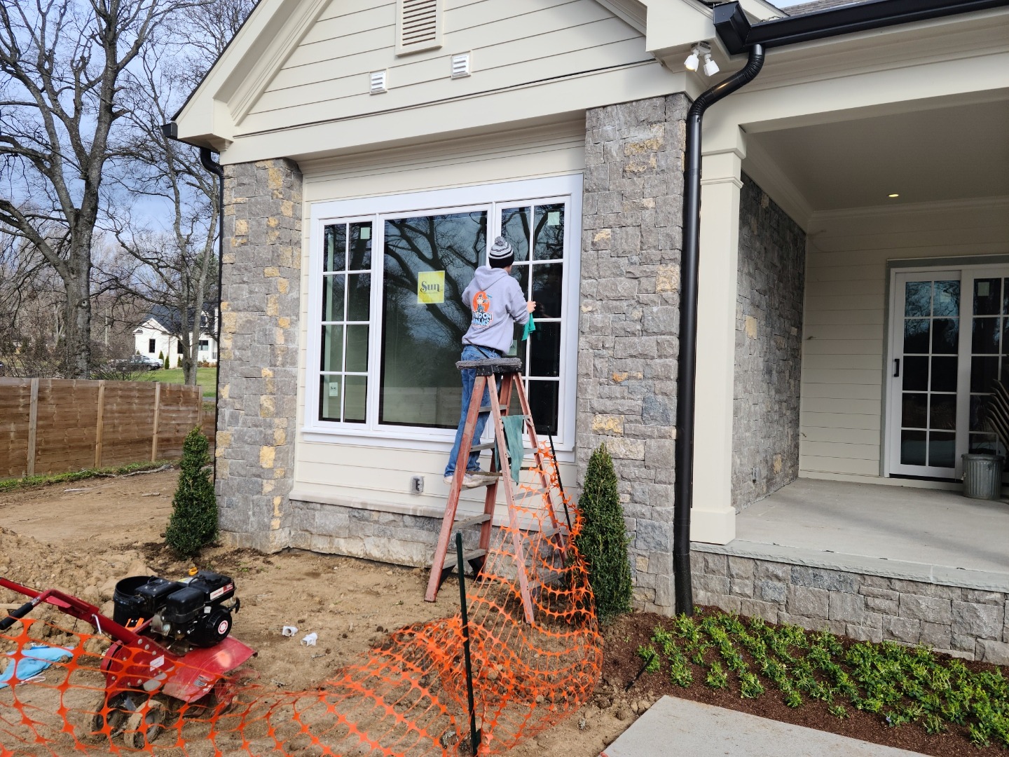 A technician from Window Ninjas outside a newly constructed home performing one of our post construction window cleaning services.