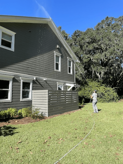 A Window Ninjas professional cleaning the soffit and roof of a residential home - we offer the best roof cleaning services.