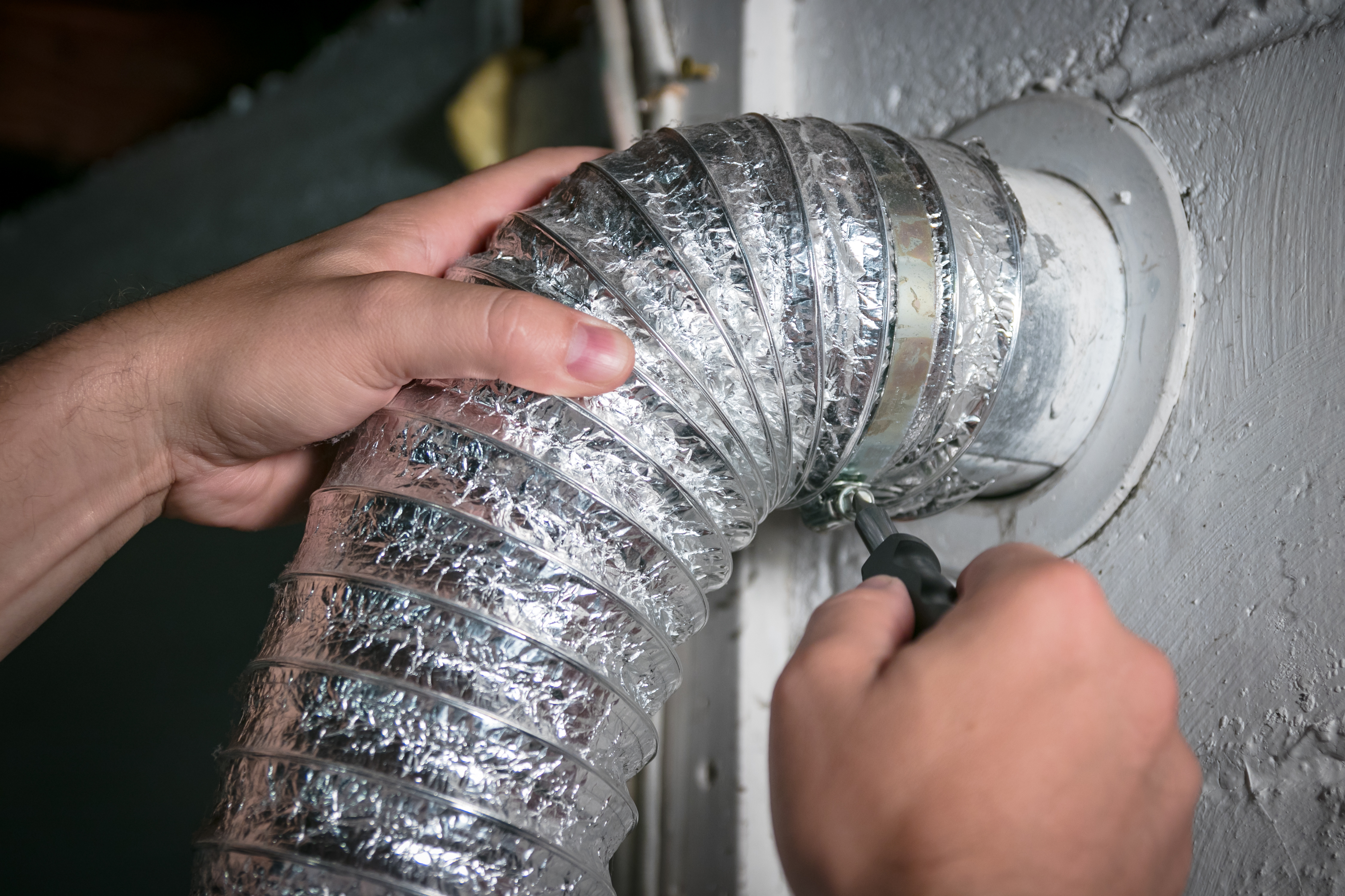 A close up of a Window Ninjas technician cleaning a dryer vent - if you are in need of services for dryer vent cleaning condominium, contact us today!