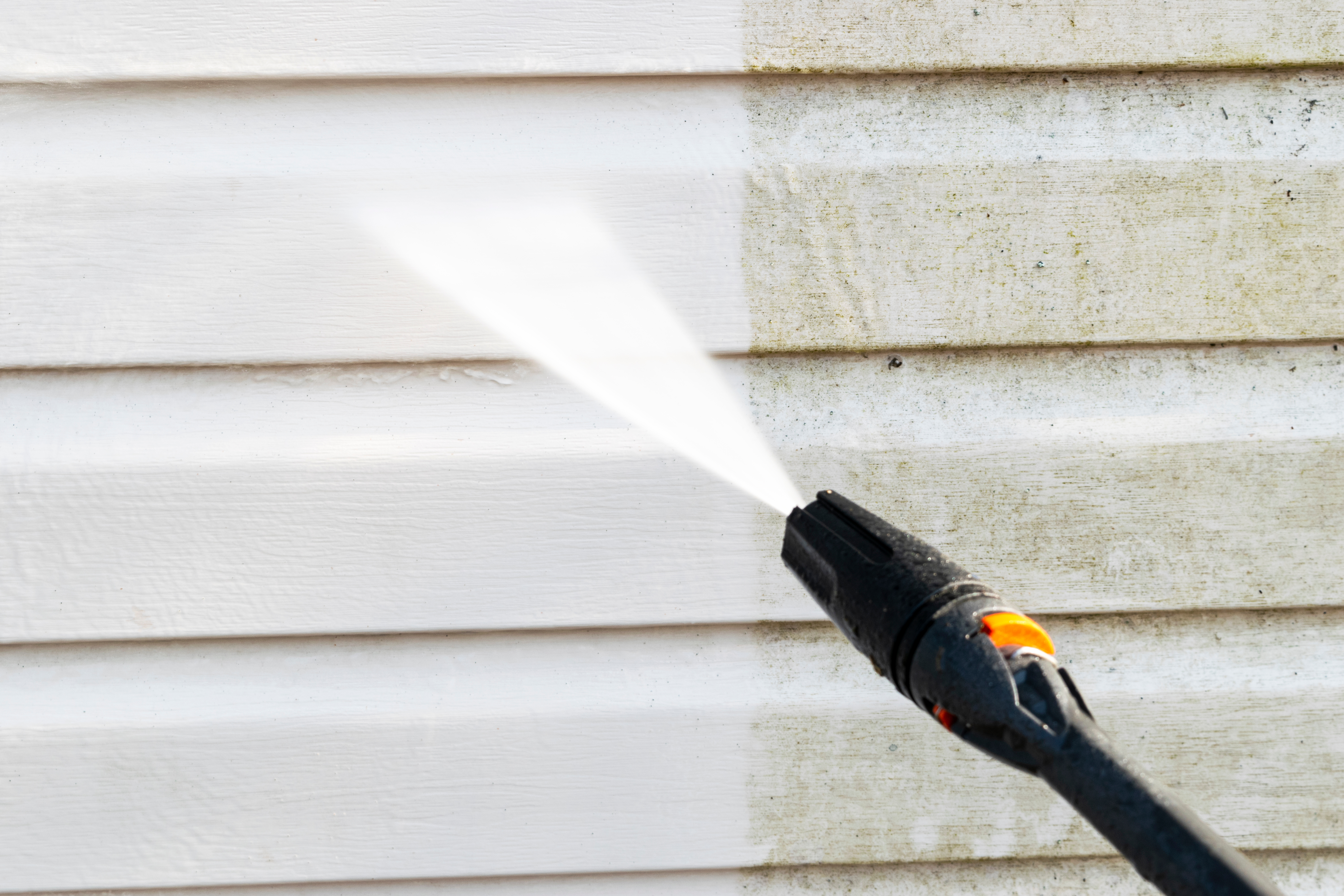 An image representing siding cleaning with a pressure washer.