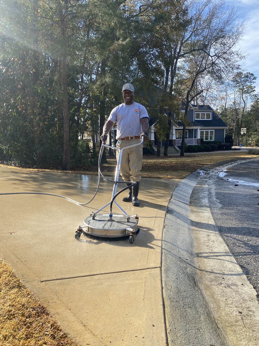 A professional power washer providing driveway and concrete cleaning.