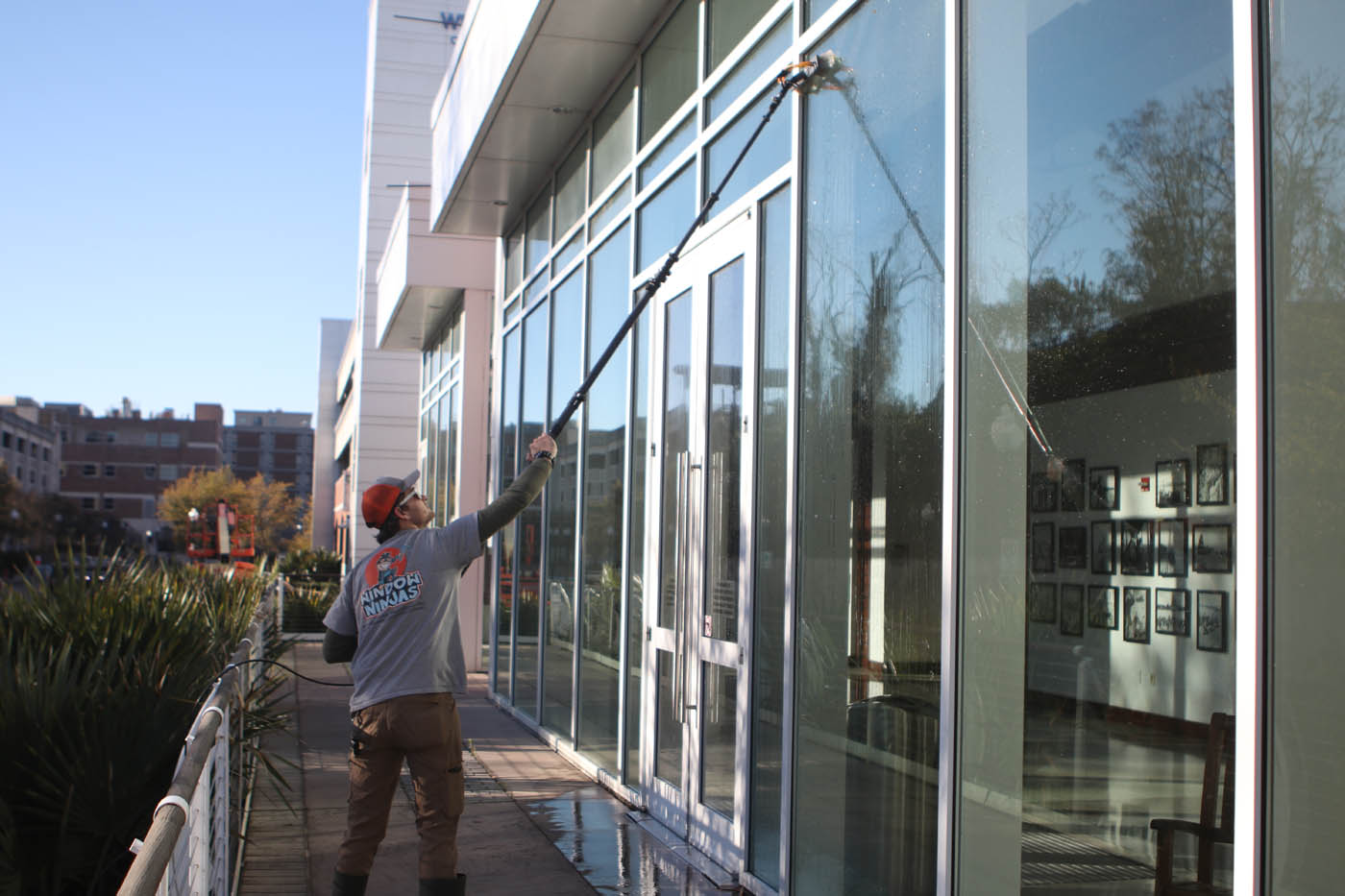 A professional from Window Ninjas performing our expert window washing services on an exterior window.