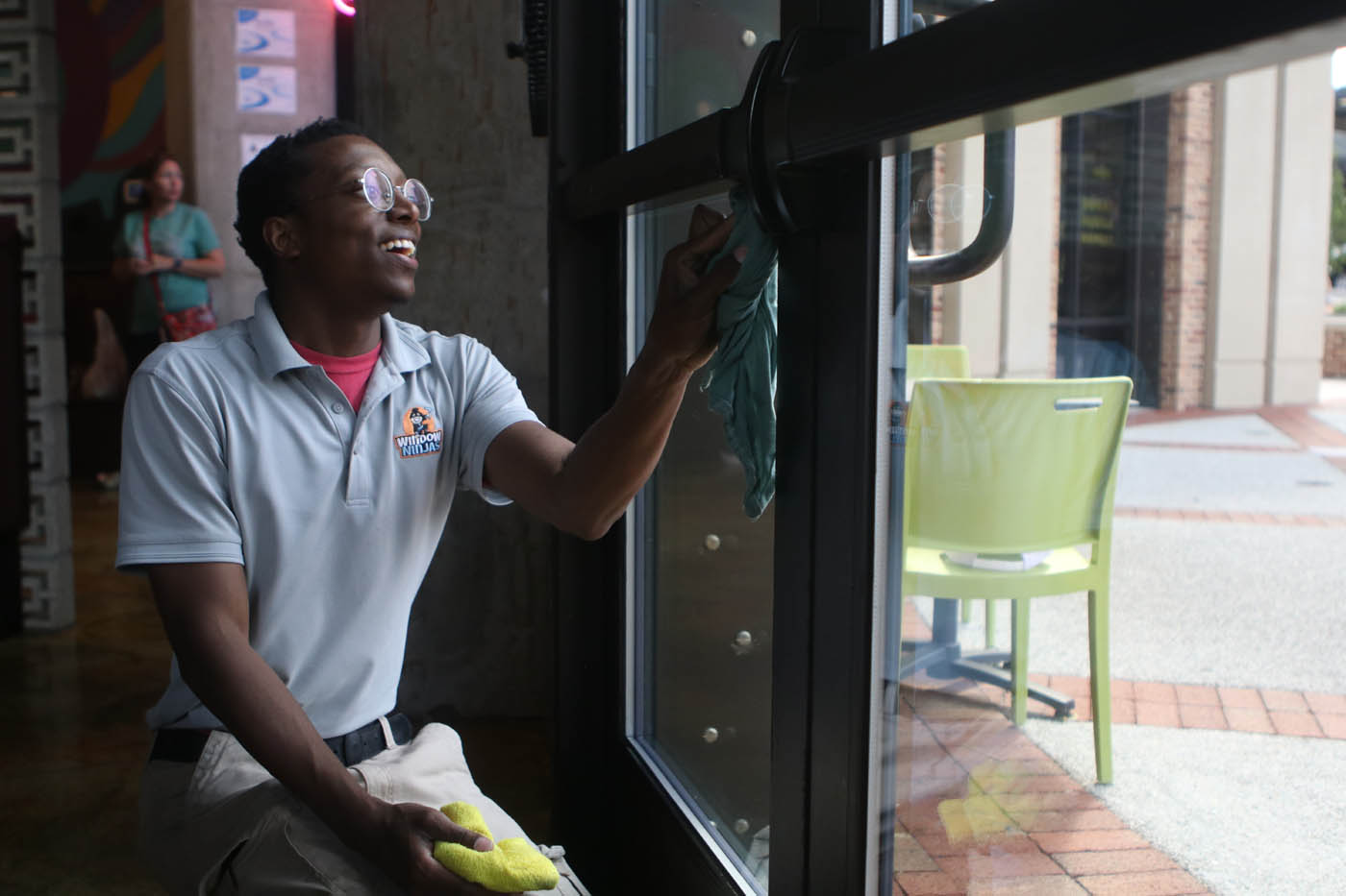 A Window Ninjas window technician cleaning the inside windows for a commercial property.